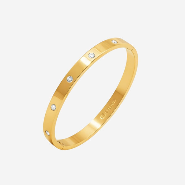 Gold bracelet with small diamonds on a light gray background