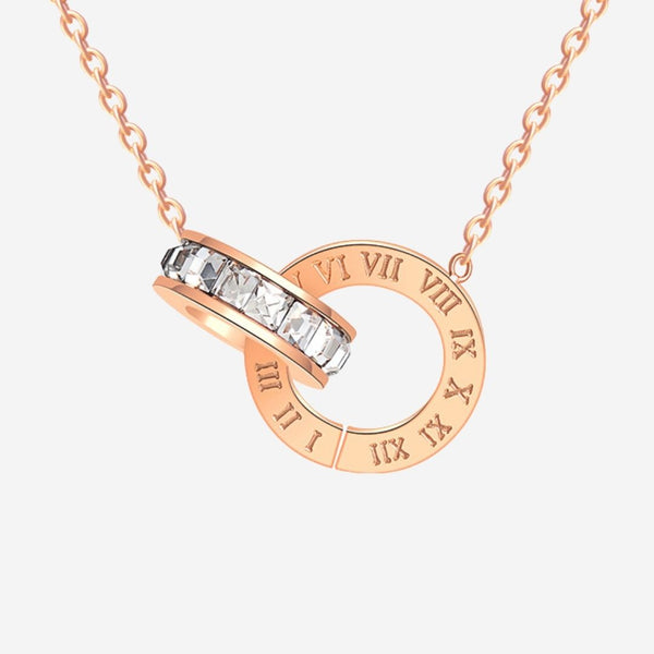 Rose gold necklace with circular pendant featuring Roman numerals and clear stones on a white background