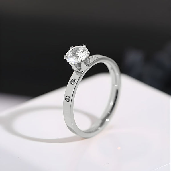 Silver ring with a clear gemstone on a white surface